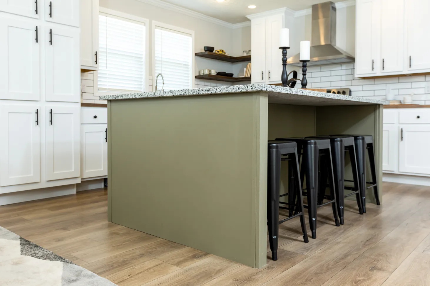 Low-angle shot of kitchen island with green base and black-and-white speckled countertop