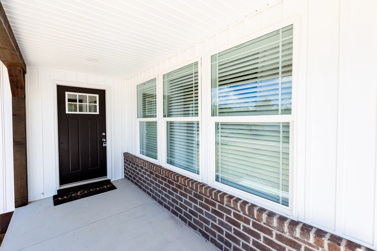 Front porch of white house with reddish bricks