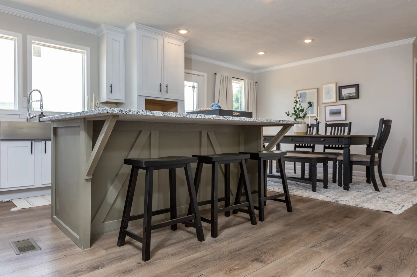 Low view of kitchen and dining room, island with overhang fitting three stools