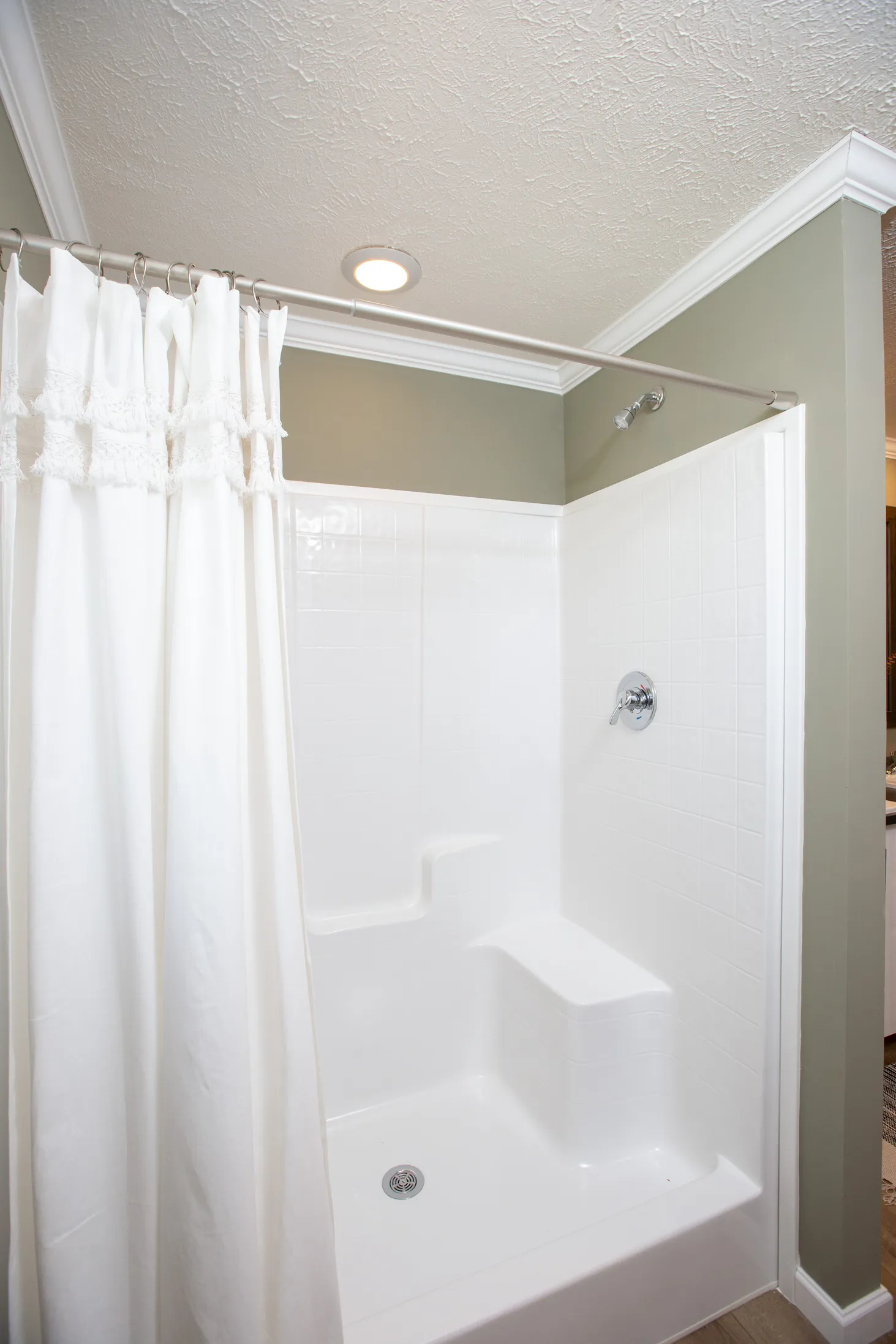 Close-up shot of white bathtub with white shower curtain