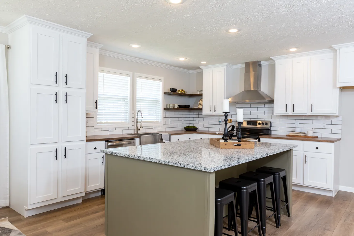 Kitchen with island with green base and black-and-white speckled countertop