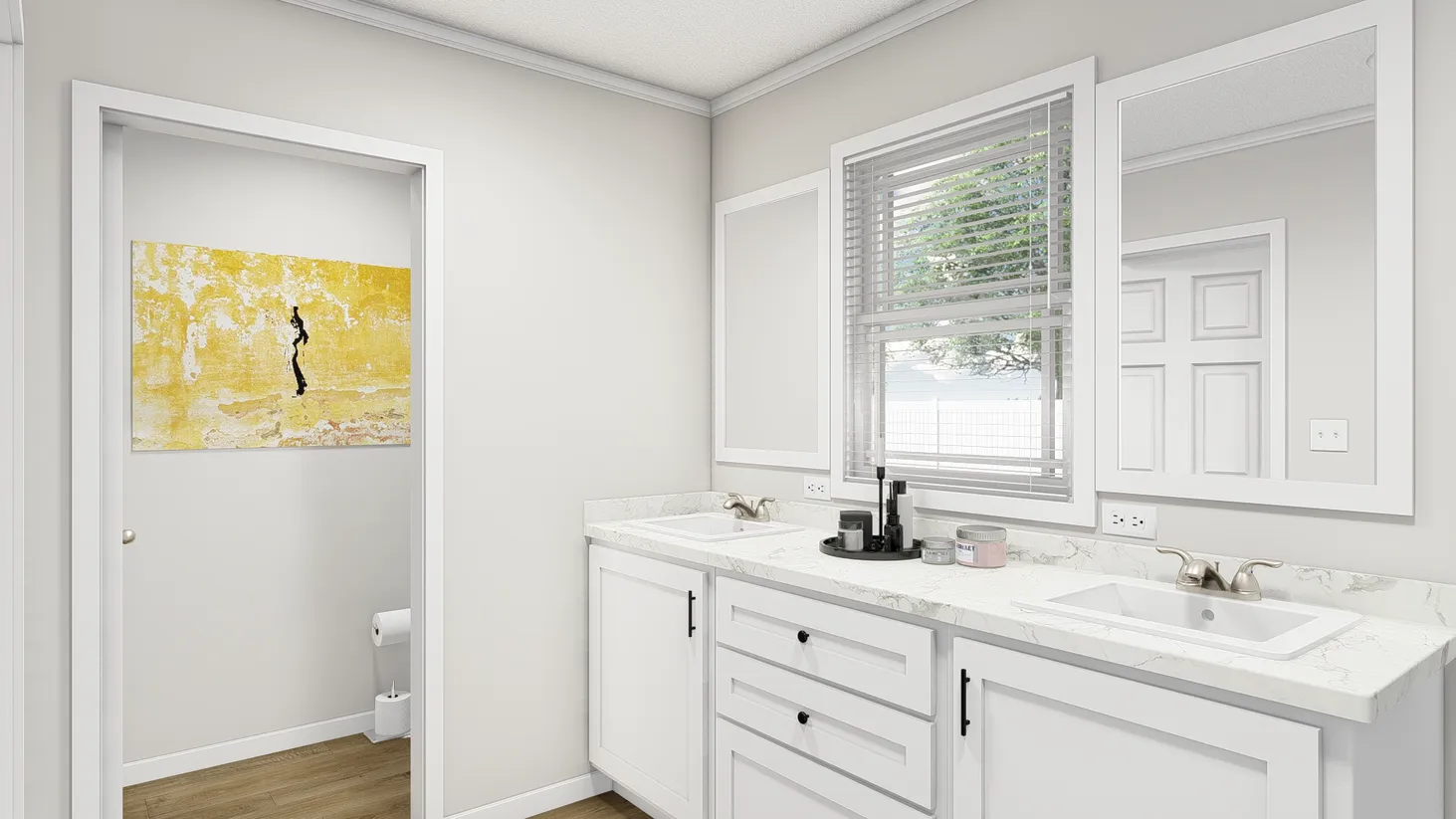 Clean white bathroom with double sink, showing a doorway leading to a room with the toilet