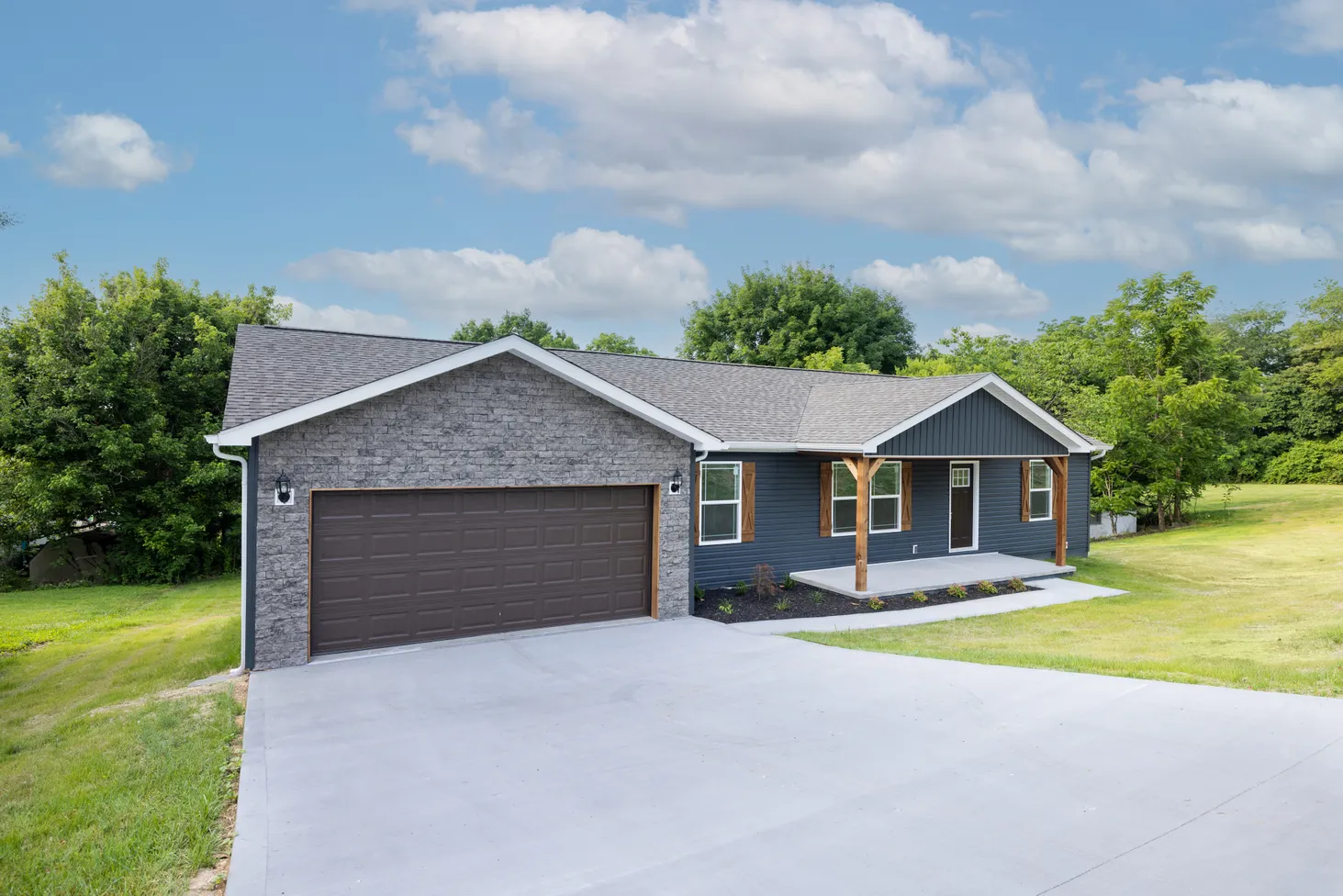 Full corner view of a blue house with wooden accents and gray bricks