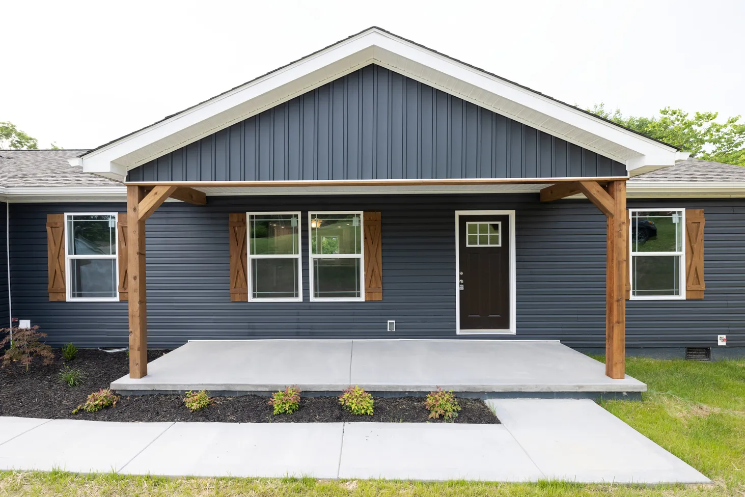 Close-up of front porch on a blue house with wooden accents