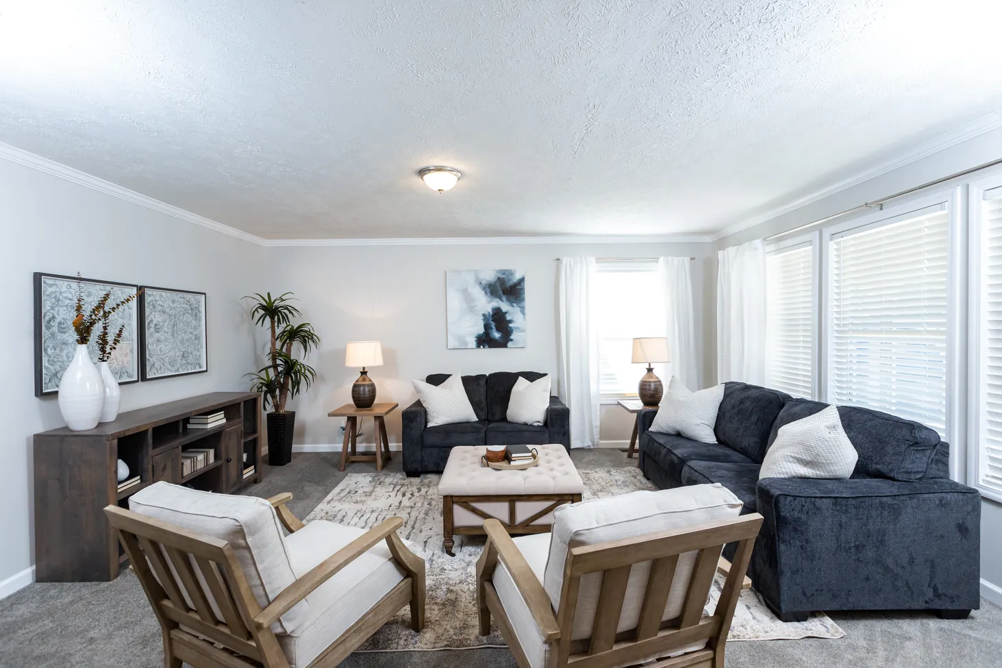 Large living room centered around a coffee table, with a large couch, a loveseat, and two chairs